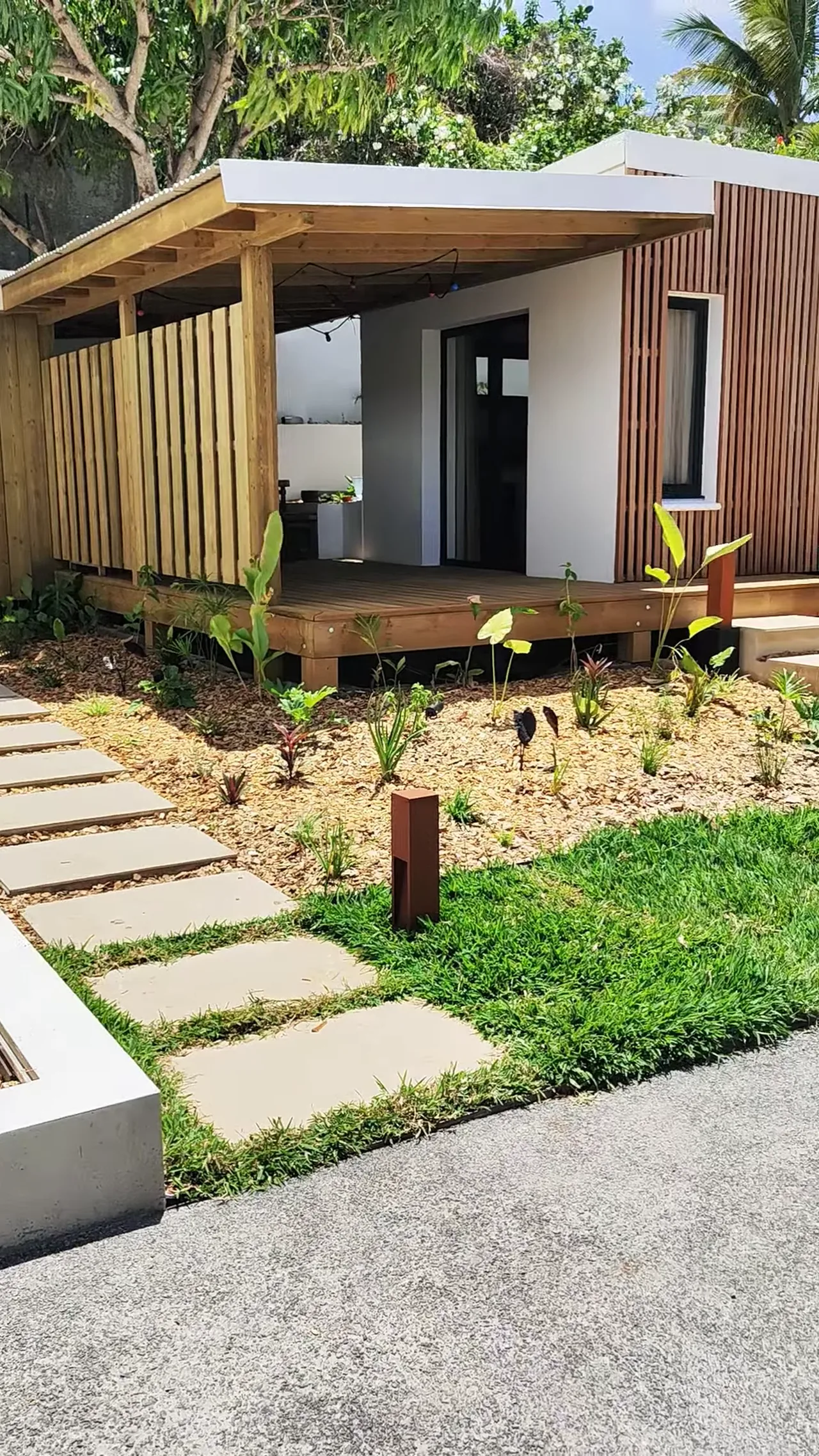 Bungalow habillé de bois avec allée en béton désactivé